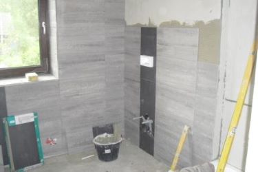 Vloertegels op wand, werk in uitvoering